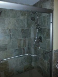 A Colorado Springs bathroom remodel with new fixtures, shower door, and tiles